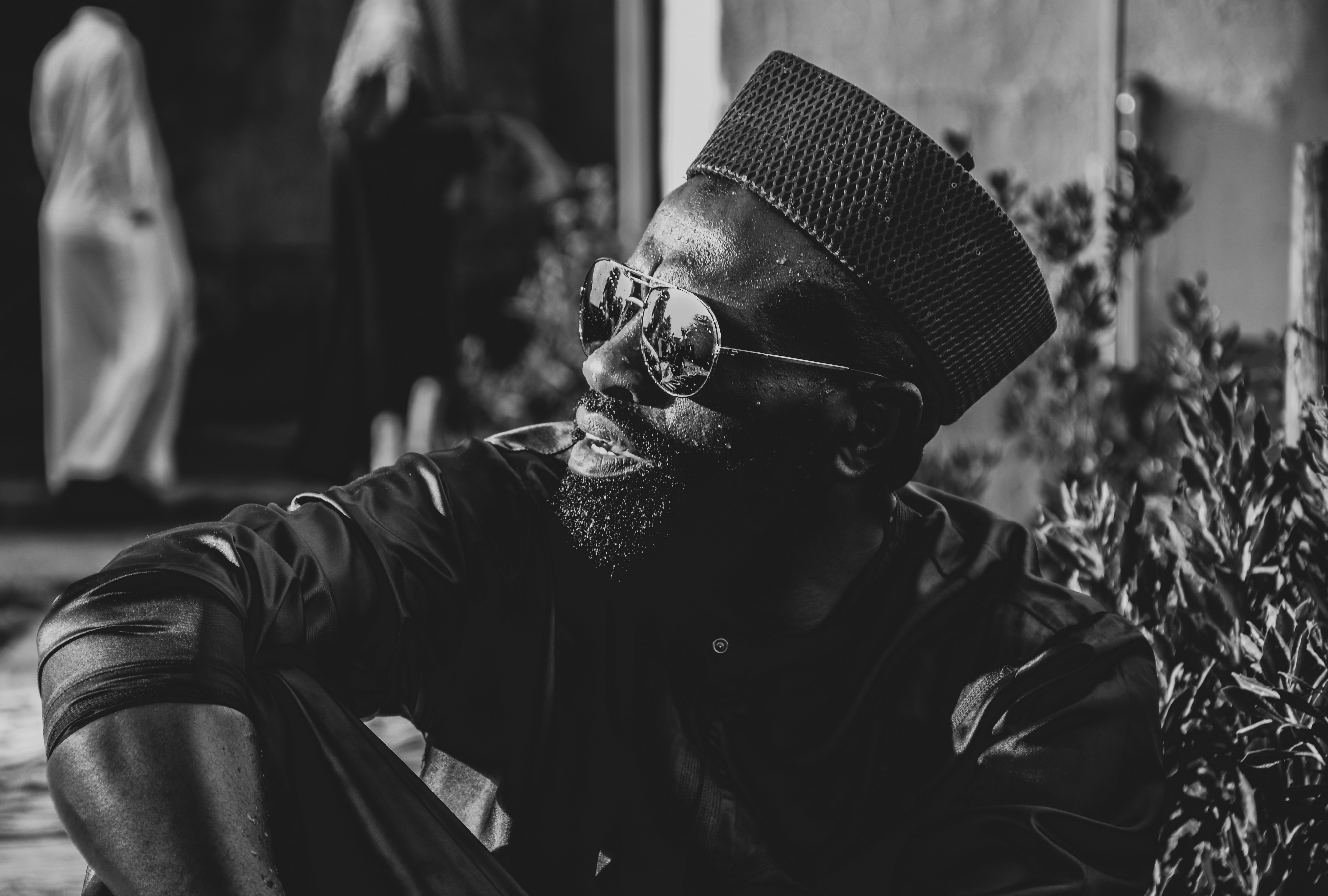 a black and white photo of a man wearing a hat