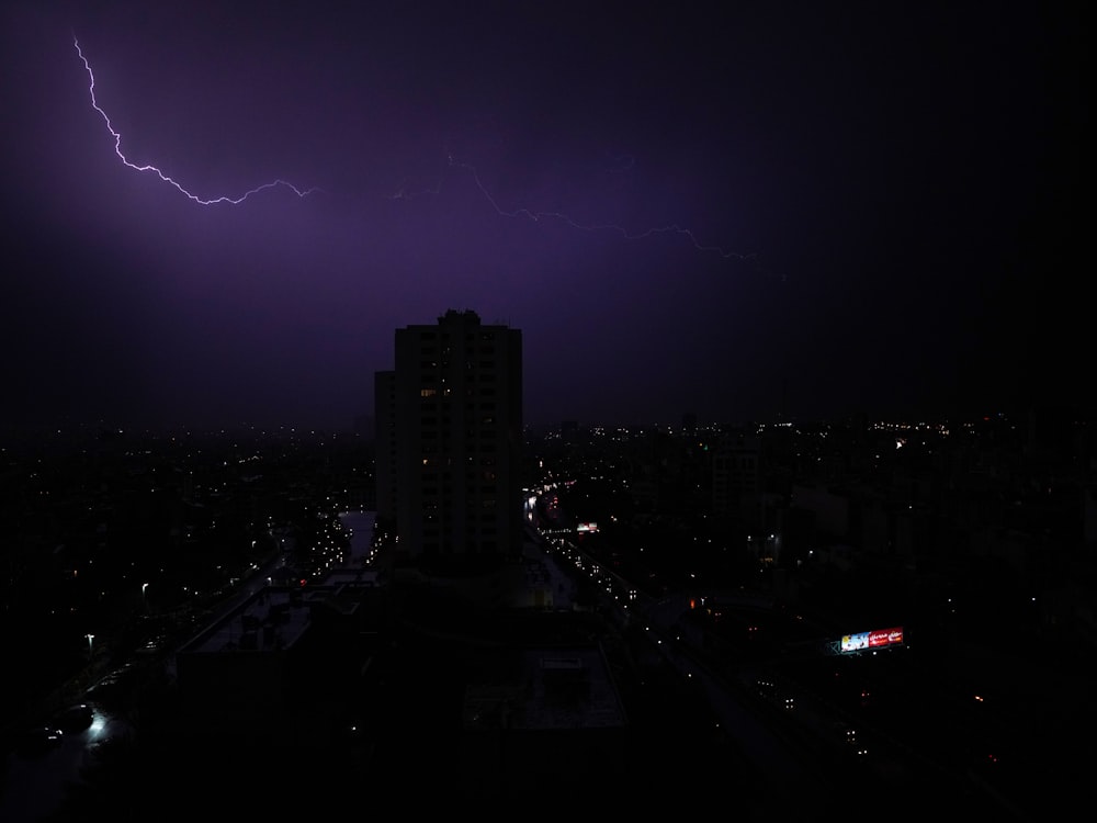 a lightning bolt strikes over a city at night