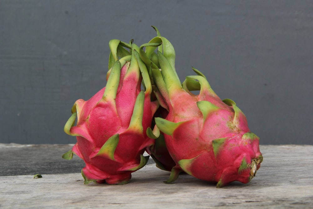 a couple of dragon fruit sitting on top of a wooden table
