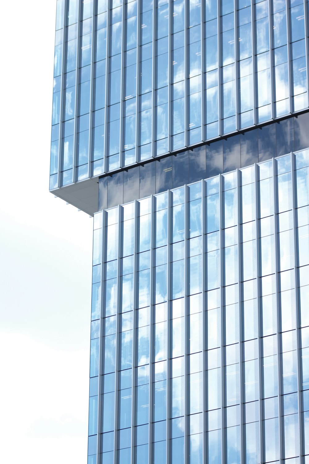 a tall glass building with a sky background