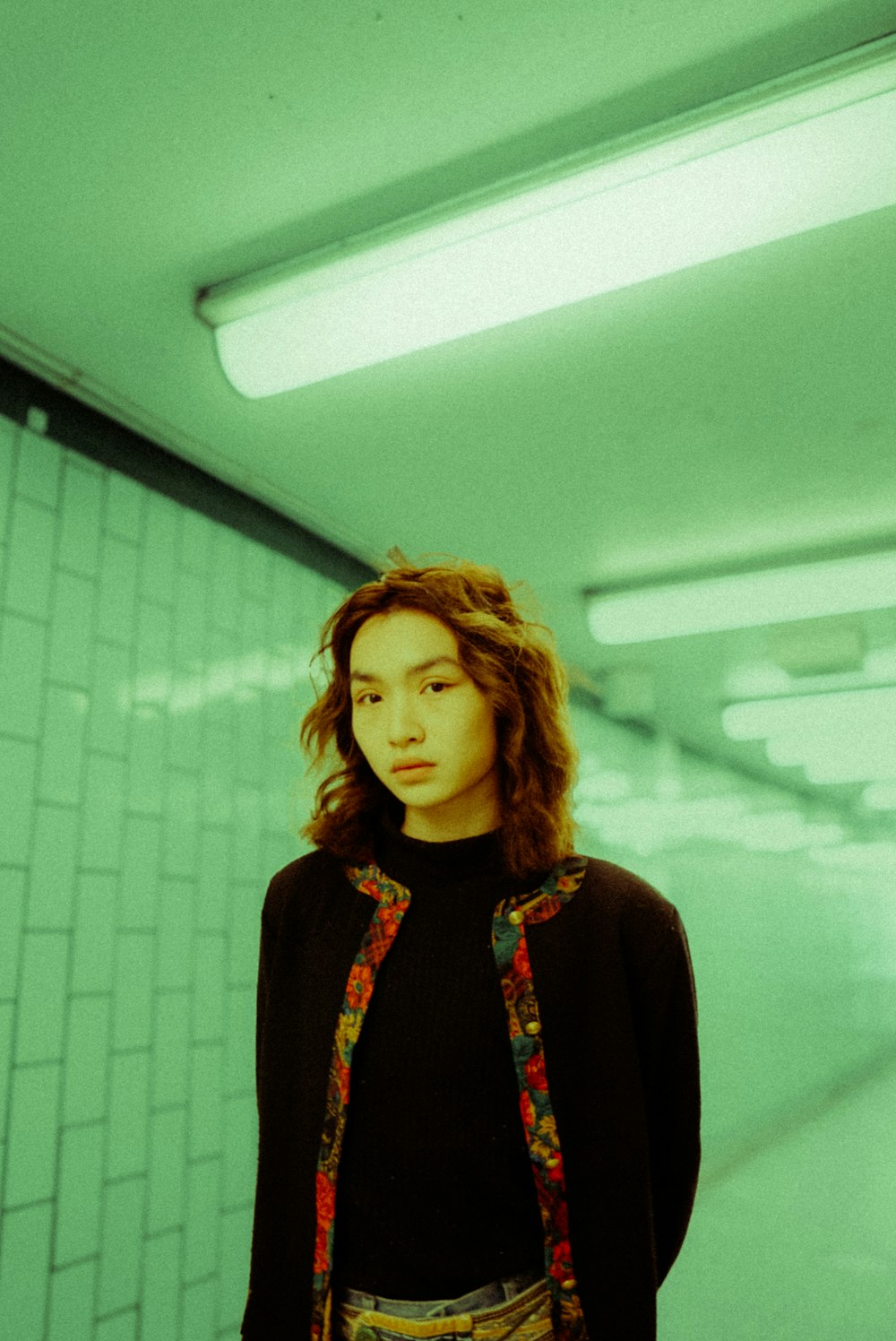 a young woman standing in a subway station