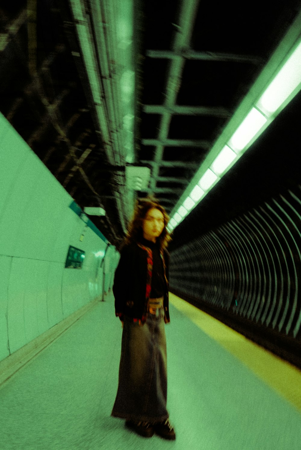 a woman in a long skirt standing in a tunnel