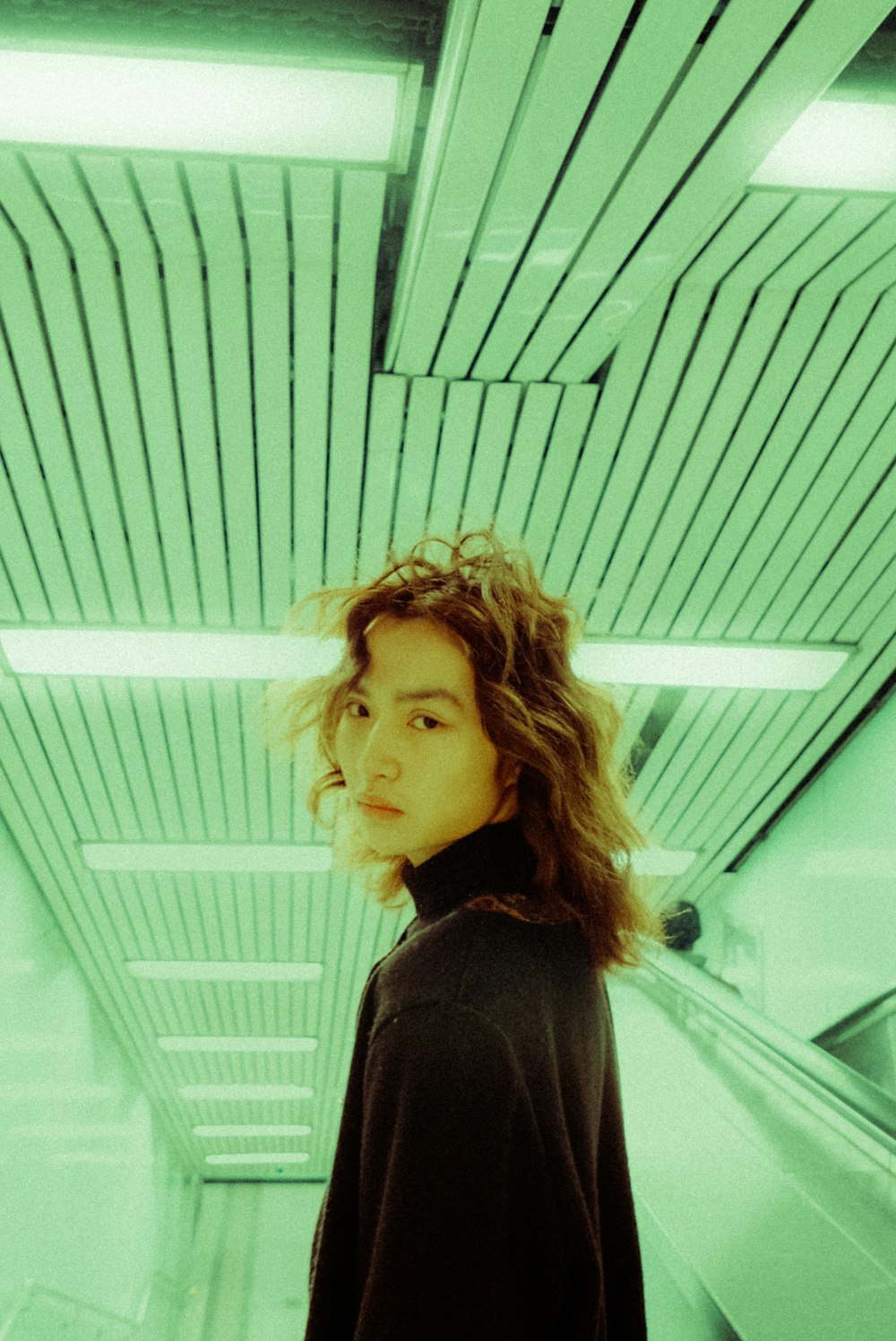 a woman standing on an escalator in a building