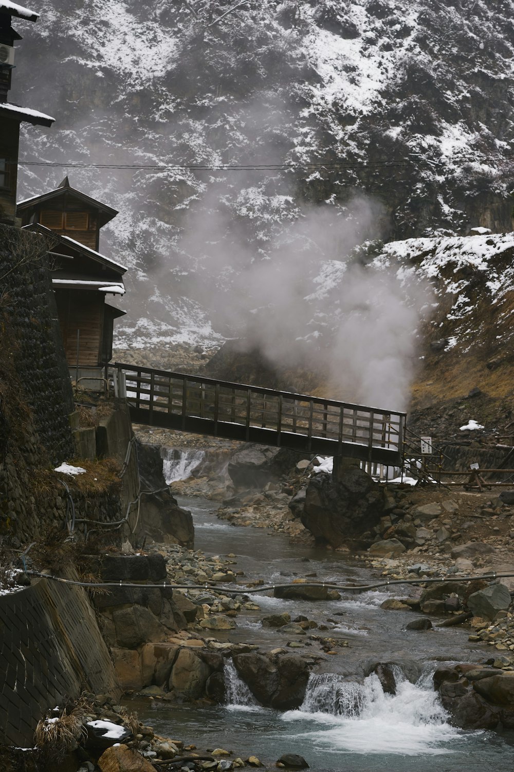 a bridge over a river with a mountain in the background