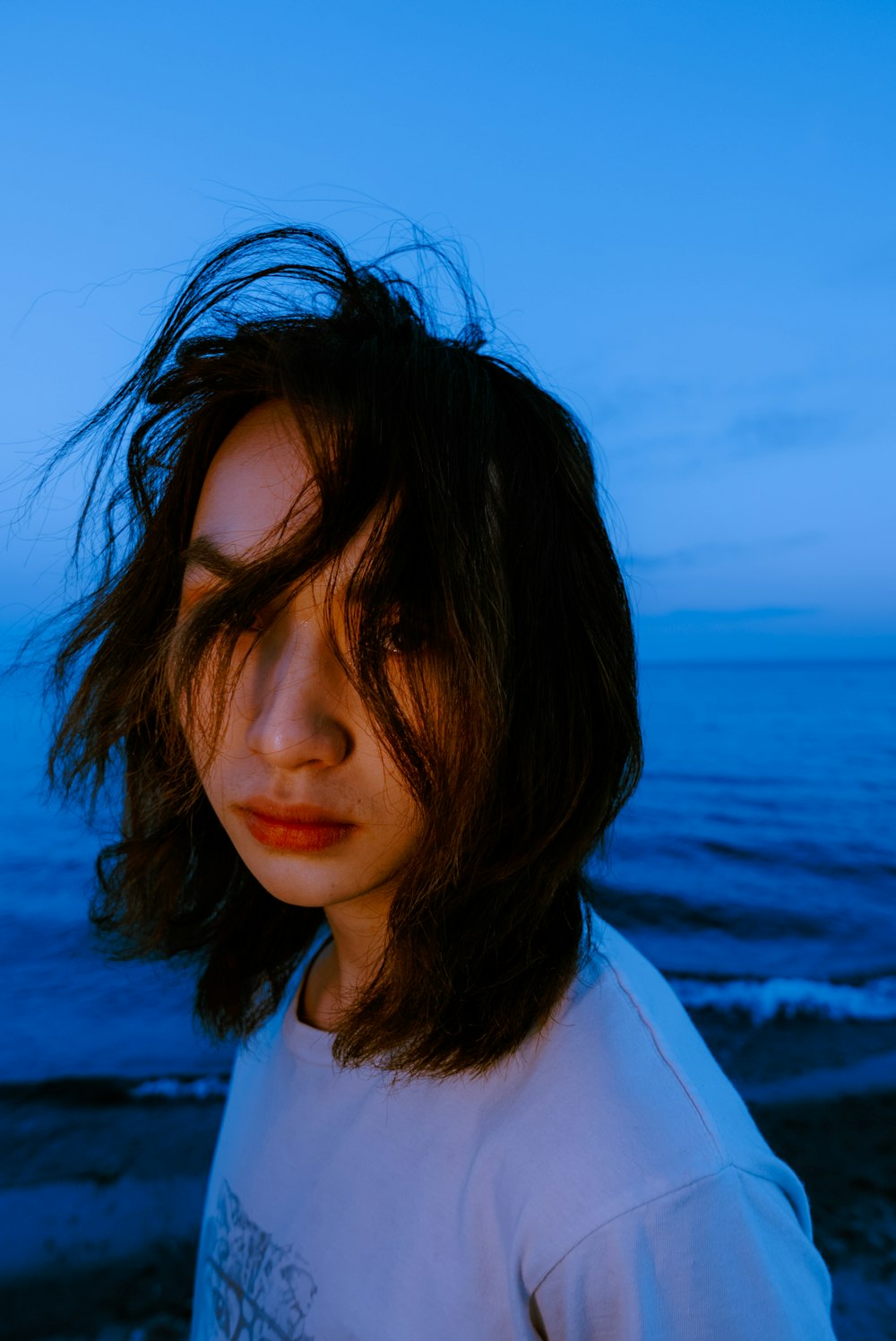 a woman standing on a beach next to the ocean