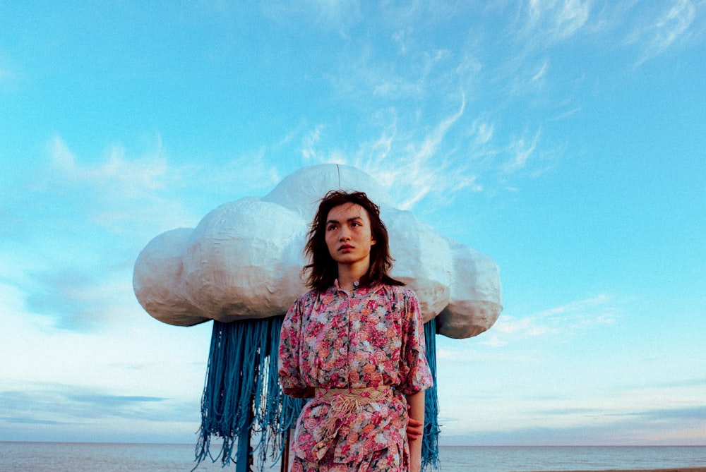 eine Frau steht am Strand mit einer großen Wolke über dem Kopf