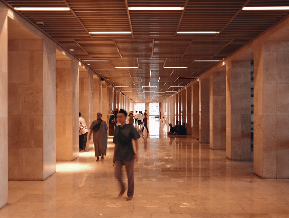 a group of people walking down a long hallway