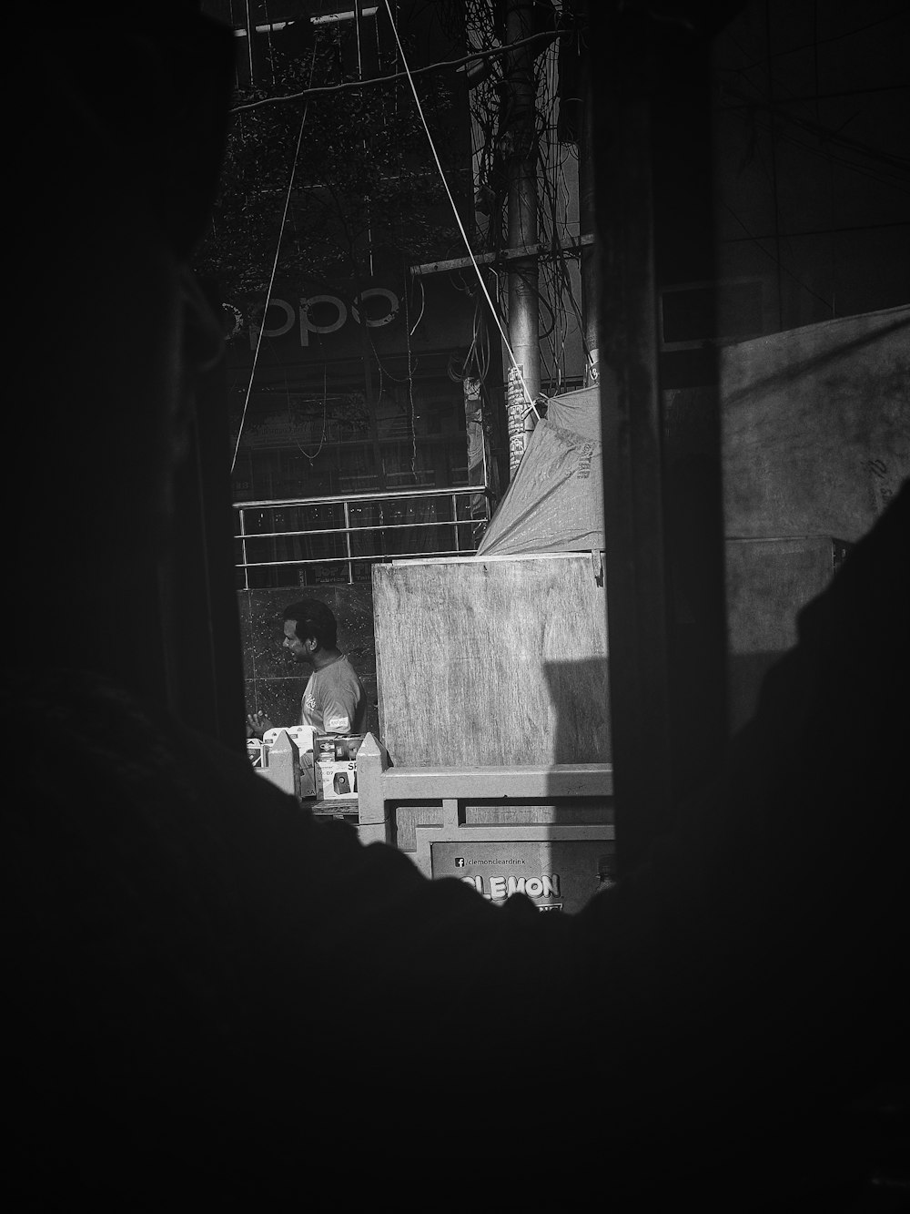 a black and white photo of a man sitting on a bench