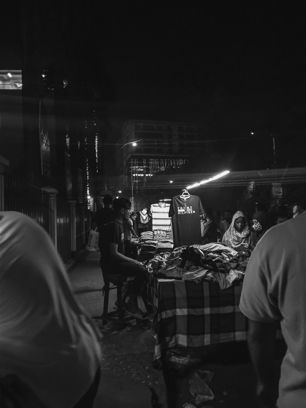 a group of people standing around a bed in the dark