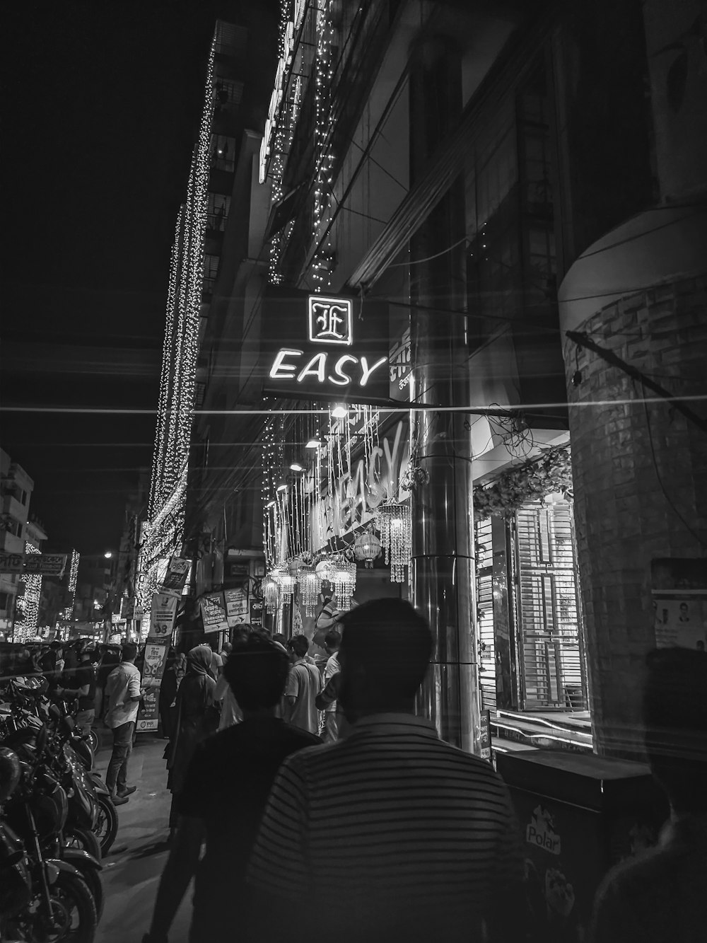 a black and white photo of a busy street at night
