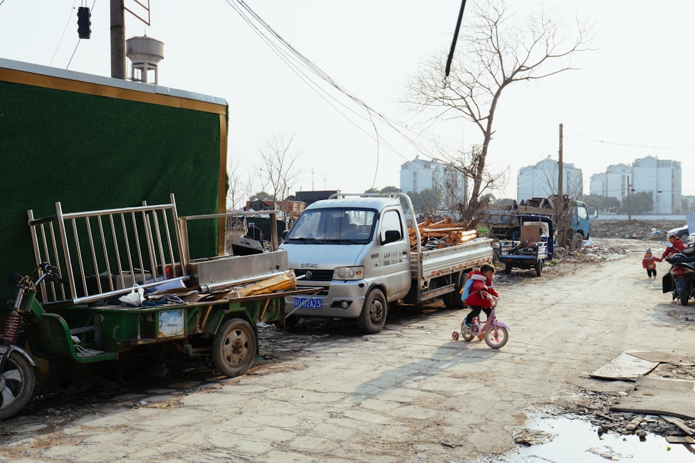 a small child riding a bike down a dirt road