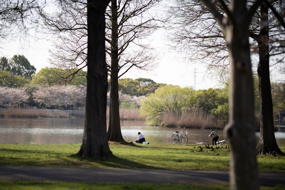 a couple of people sitting on top of a lush green field