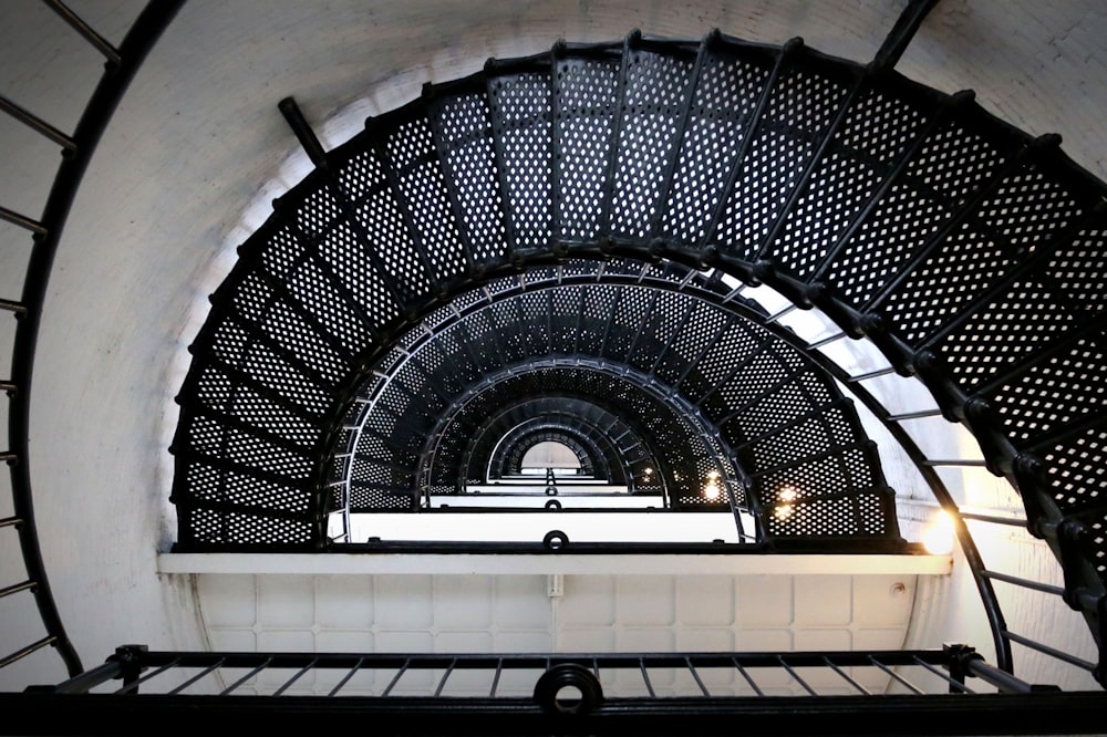 a spiral staircase in a building with a light at the end