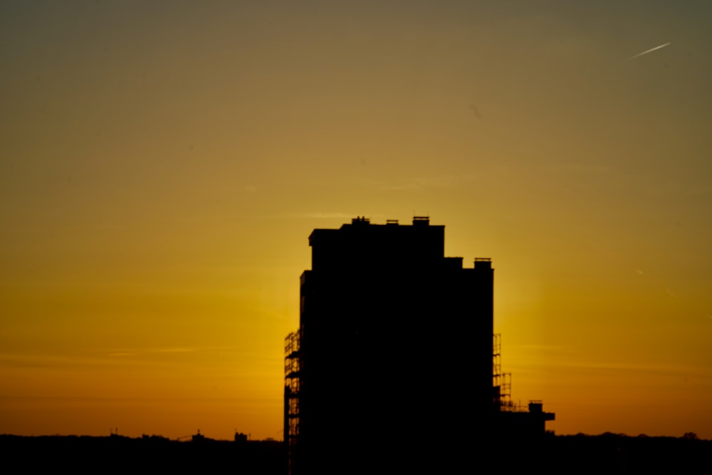 Il sole sta tramontando dietro un alto edificio