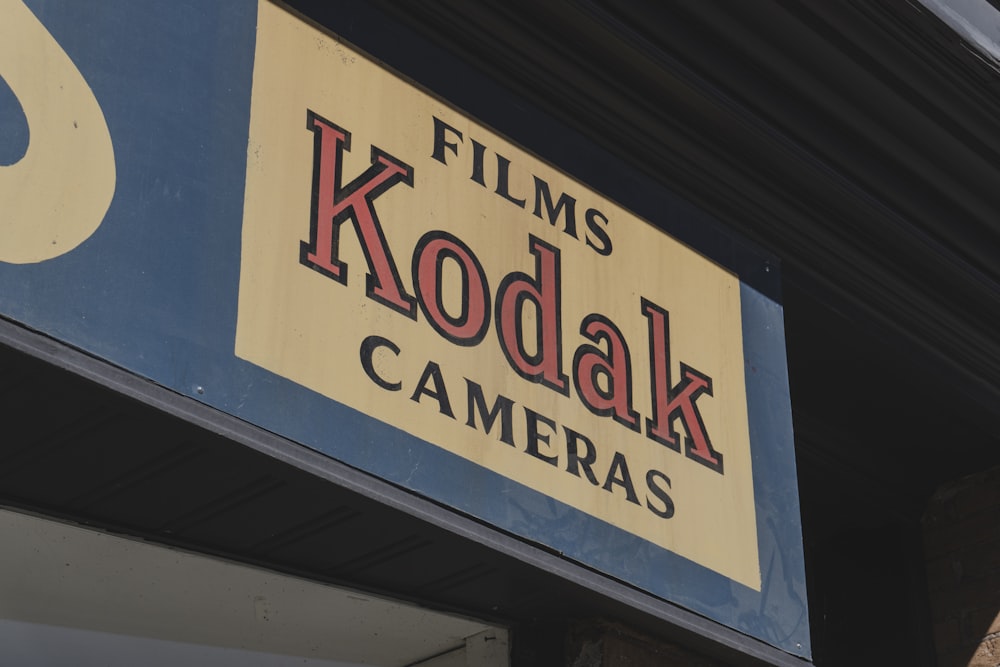 a sign for a camera shop on the side of a building