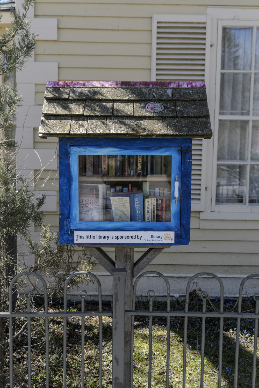 a blue box on a pole in front of a house