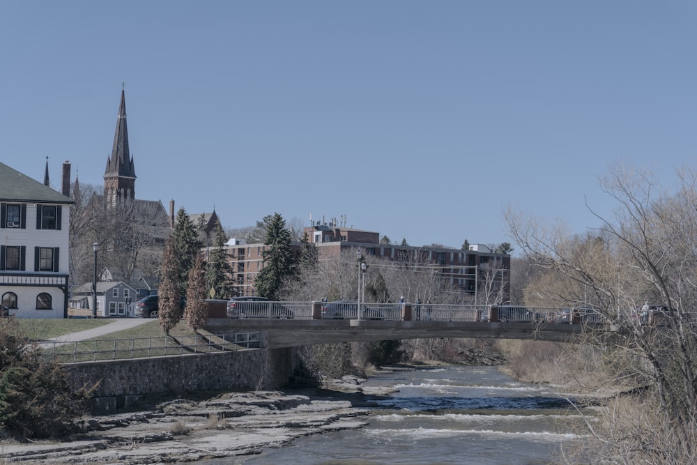 a bridge over a river with a church in the background