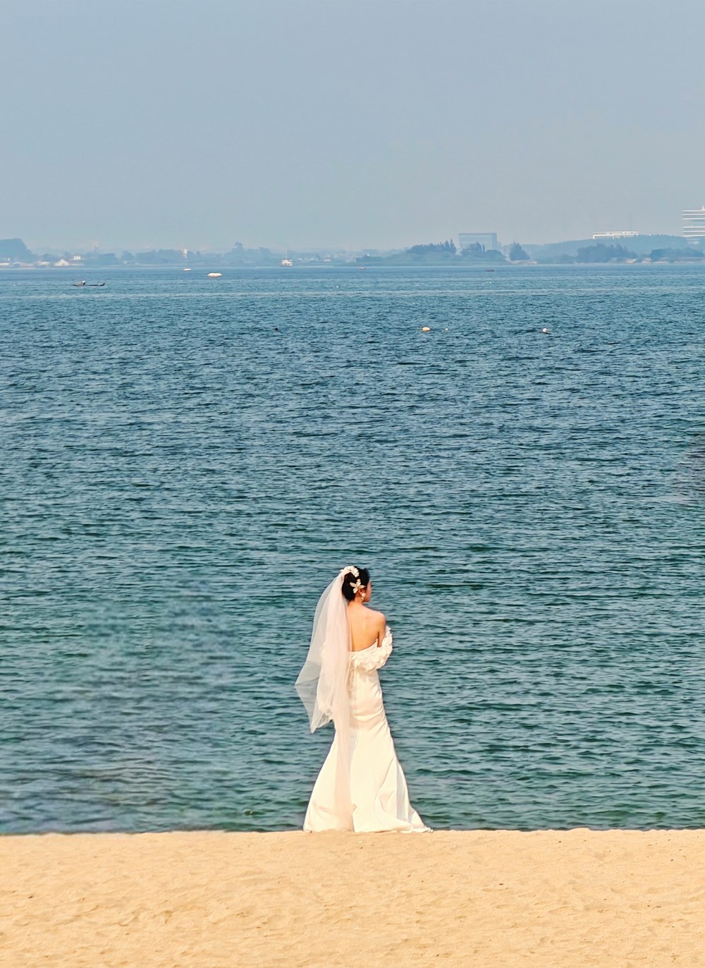 a bride and groom standing on the beach