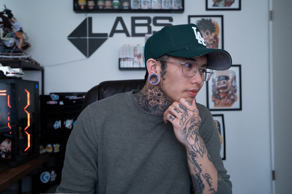 a man with a tattoo on his arm sitting in front of a tv