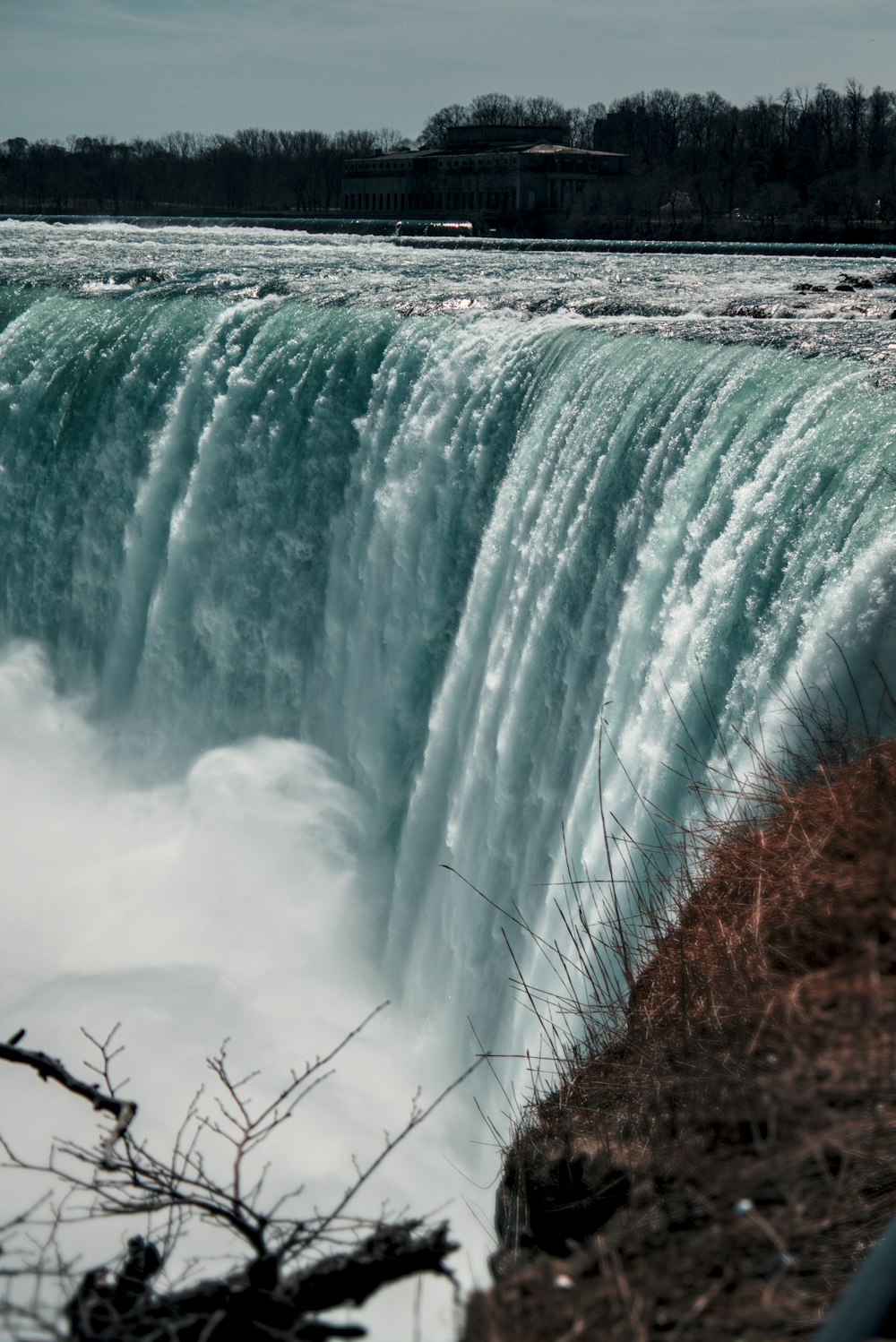 a large waterfall that is next to a body of water