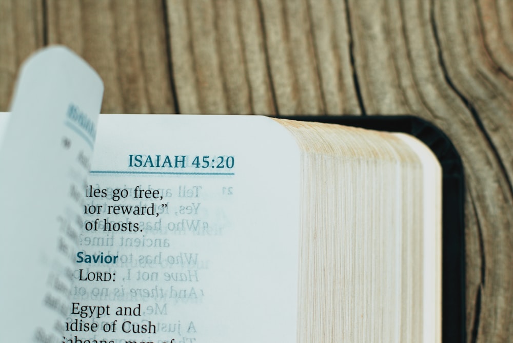 Um close up de uma Bíblia aberta em uma mesa de madeira