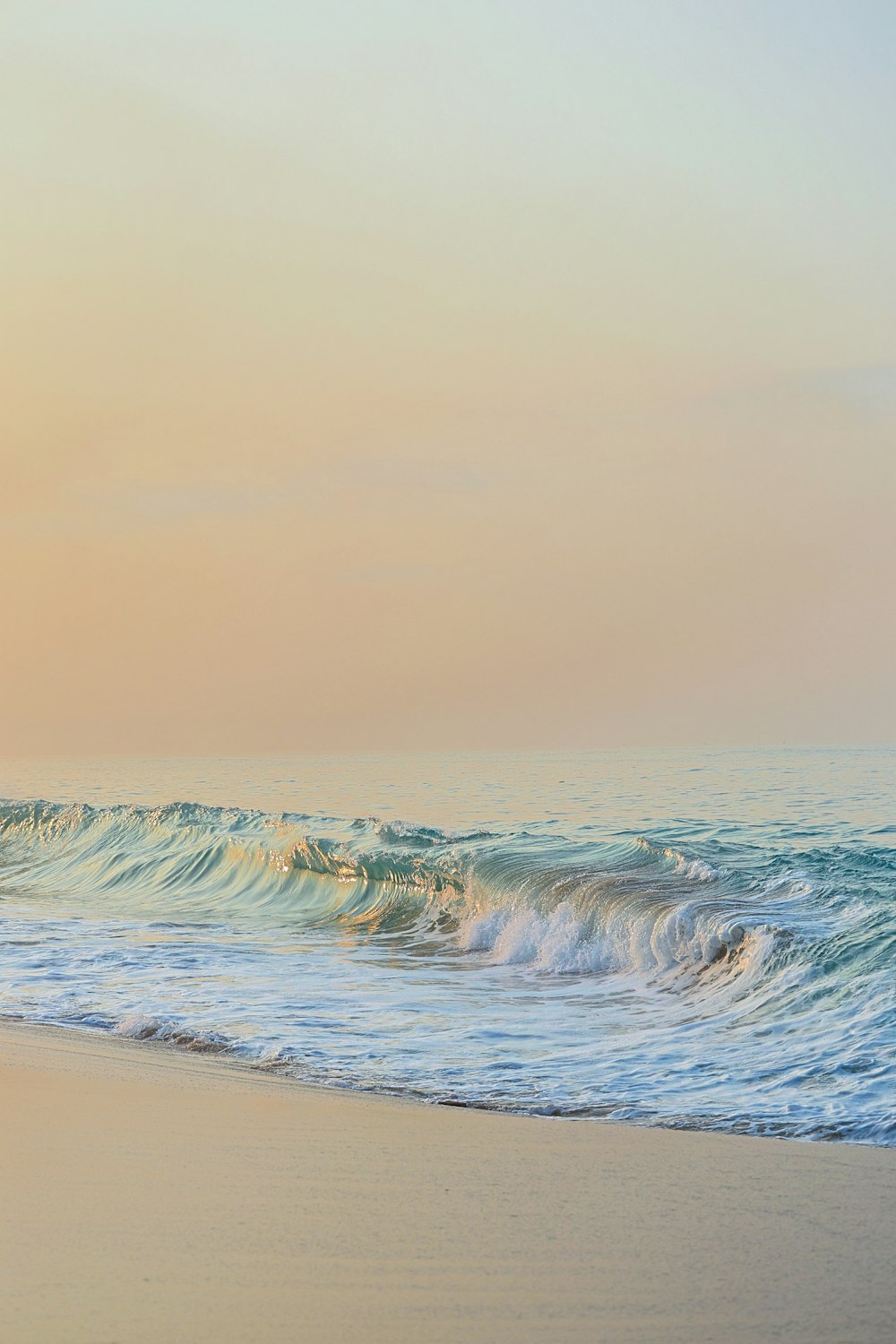 a person riding a surfboard on top of a sandy beach