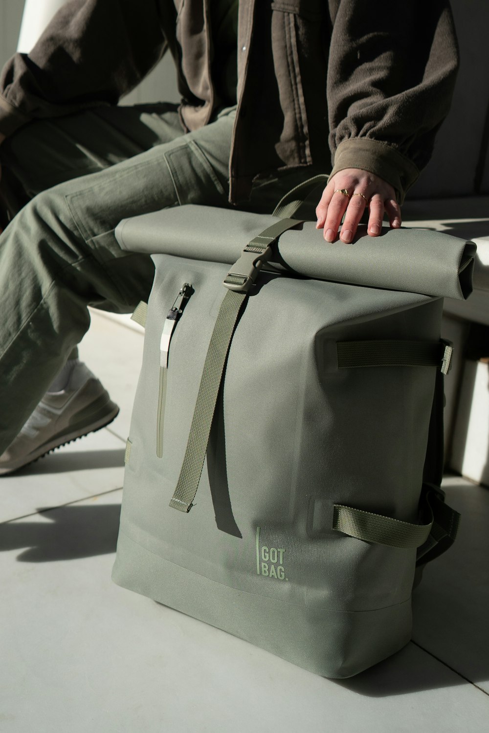 a person sitting on a bench with a bag