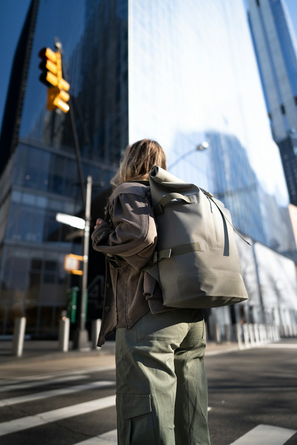 a person with a backpack is waiting at a crosswalk