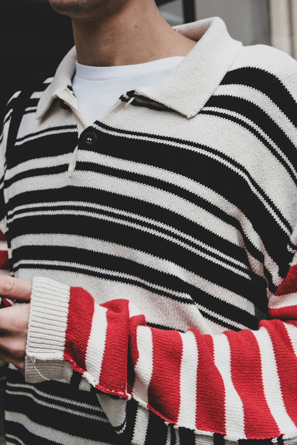 a man wearing a striped sweater and a white shirt
