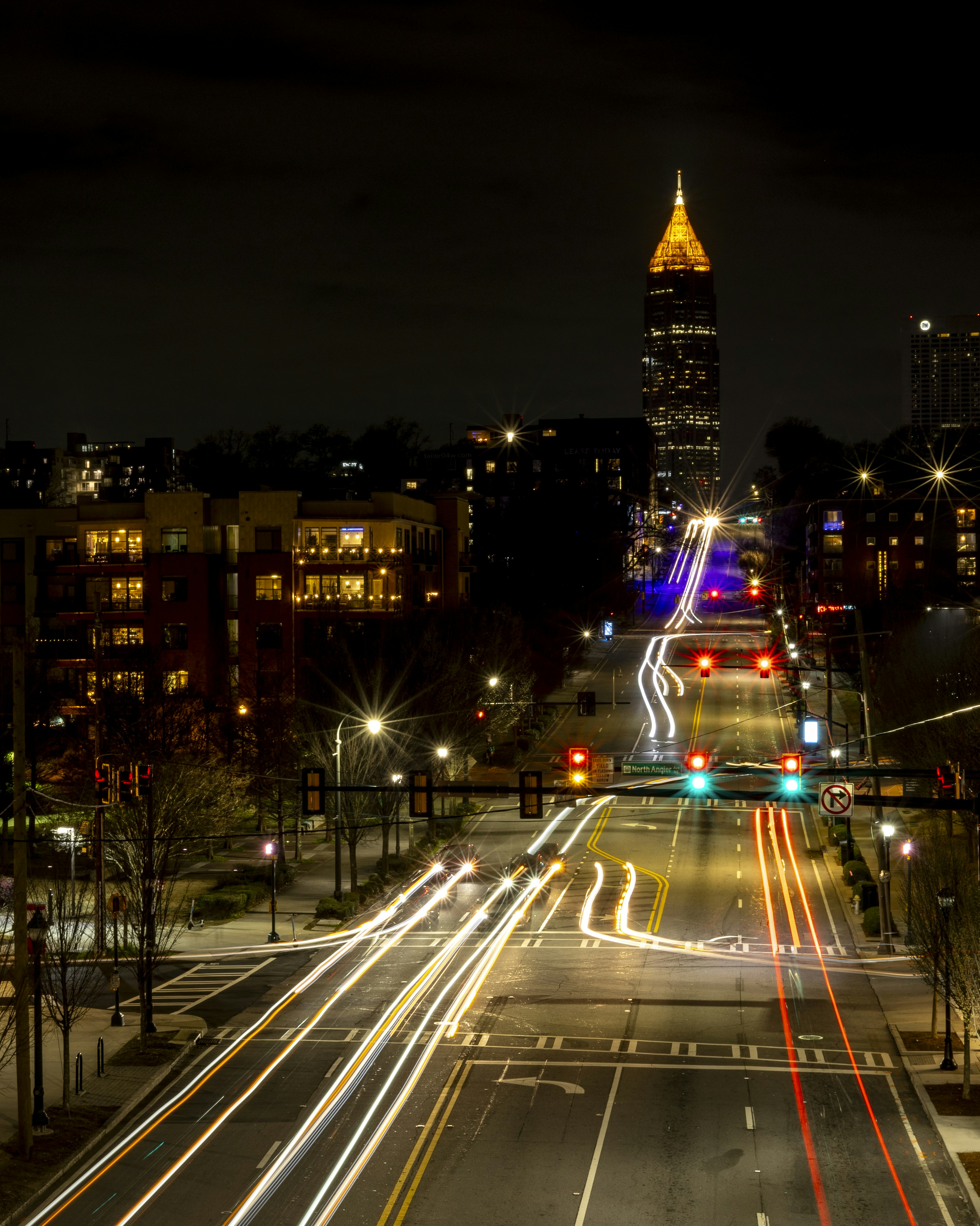 a city street at night with a clock tower in the background