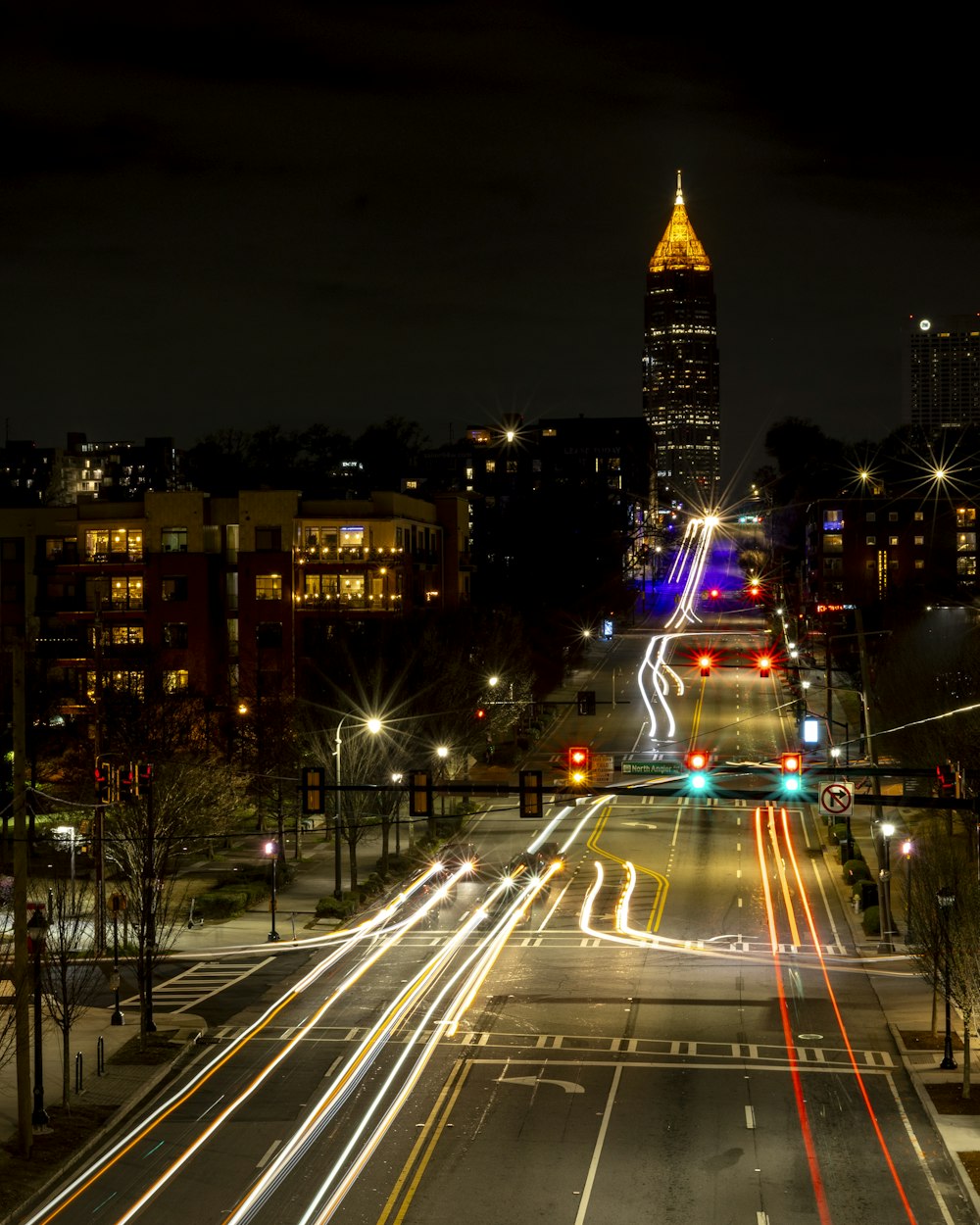 a city street at night with a clock tower in the background