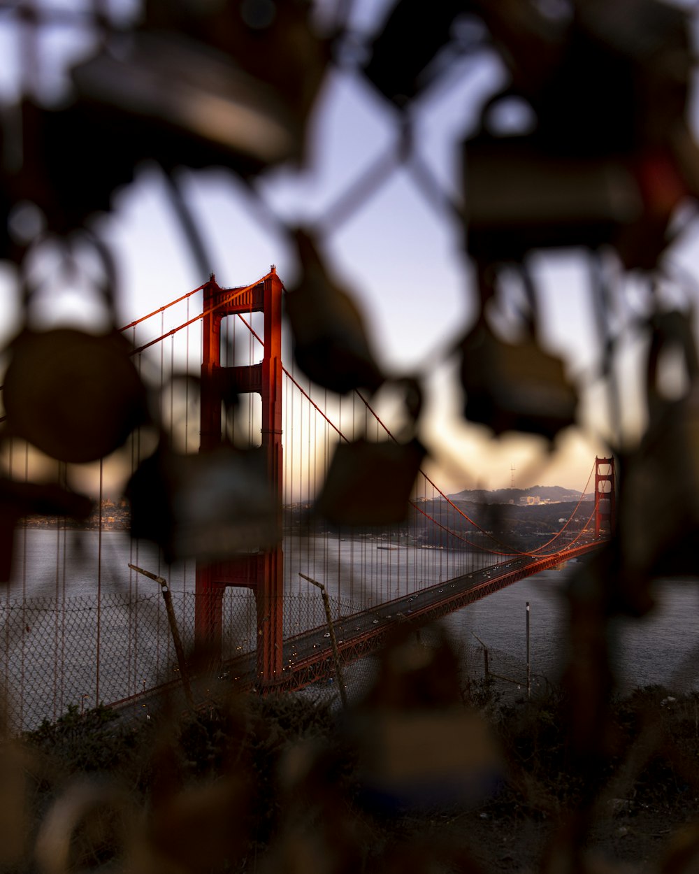 a view of the golden gate bridge through a fence