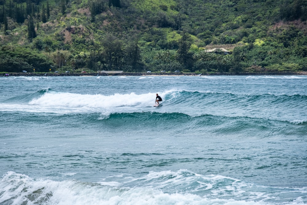 a man riding a wave on top of a surfboard