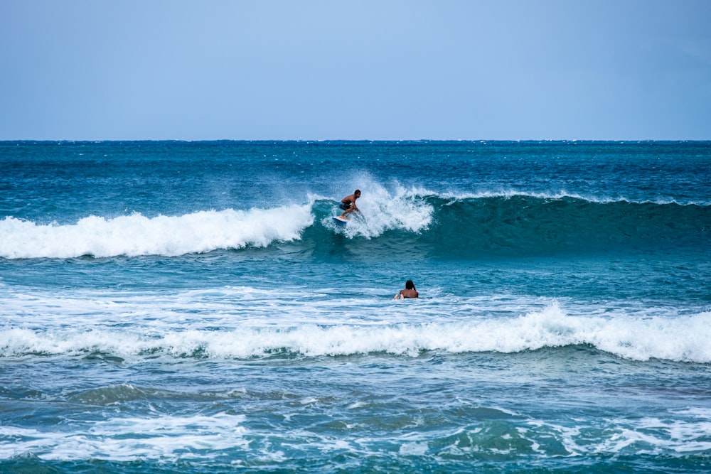 two surfers are riding a wave in the ocean