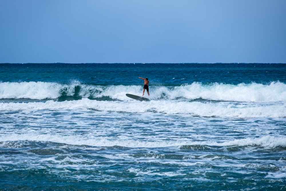 a person riding a surfboard on a wave in the ocean