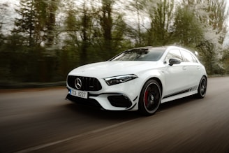 a white mercedes cla driving down a road