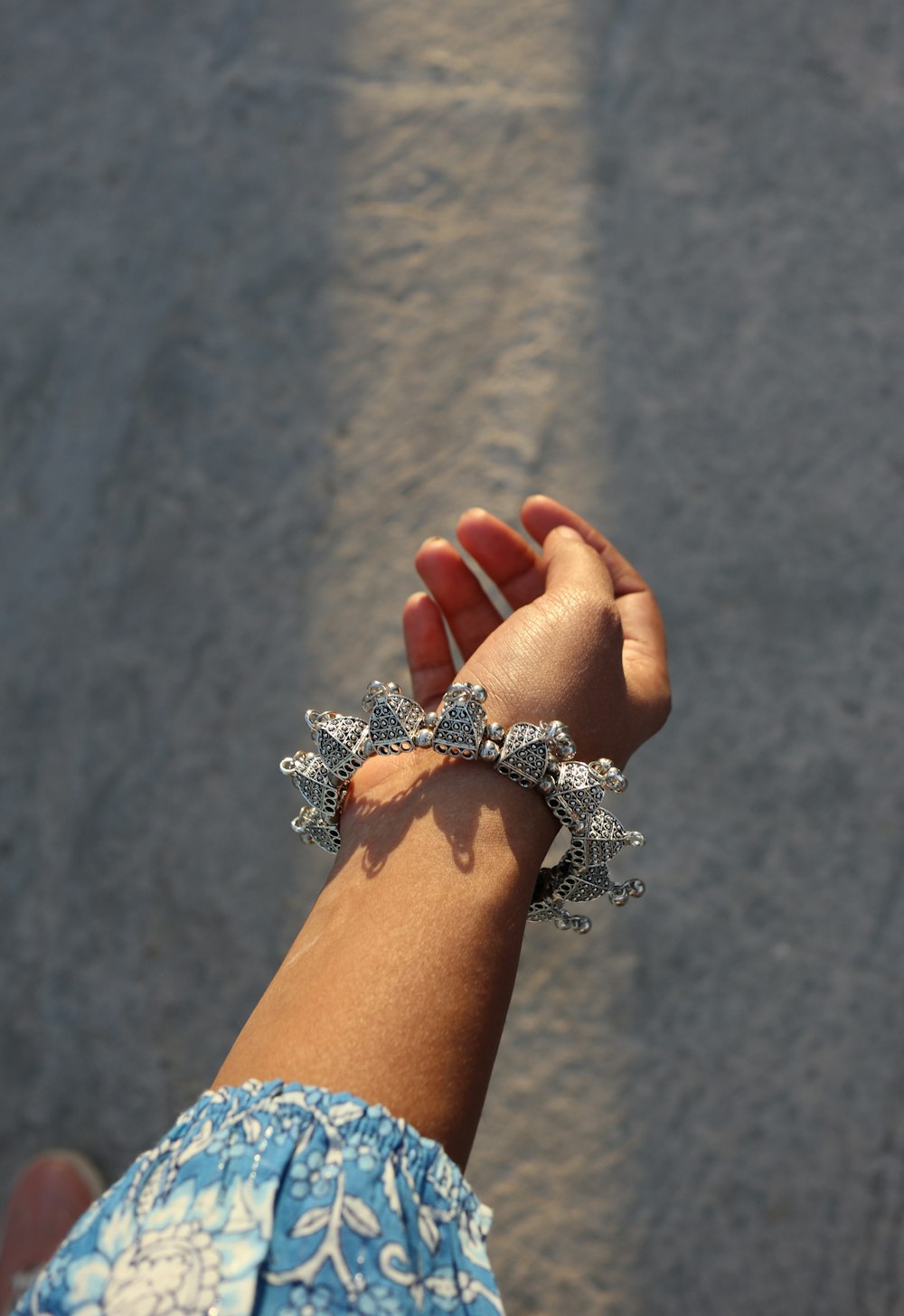 a person holding onto a bracelet on a beach