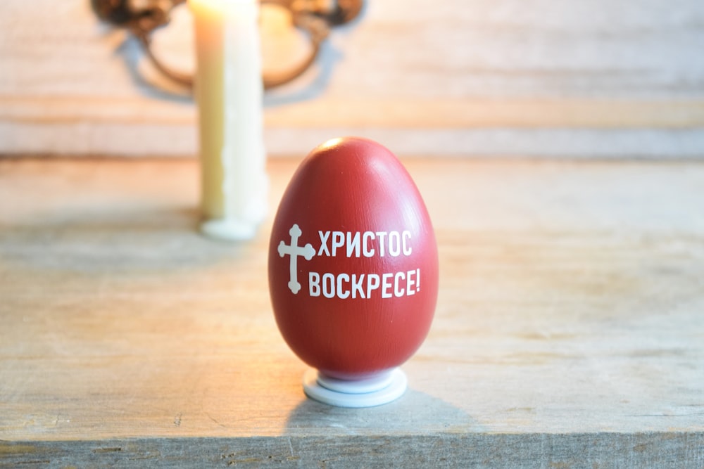 a red egg sitting on top of a wooden table