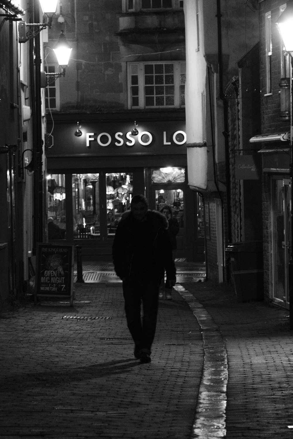 a man walking down a street at night