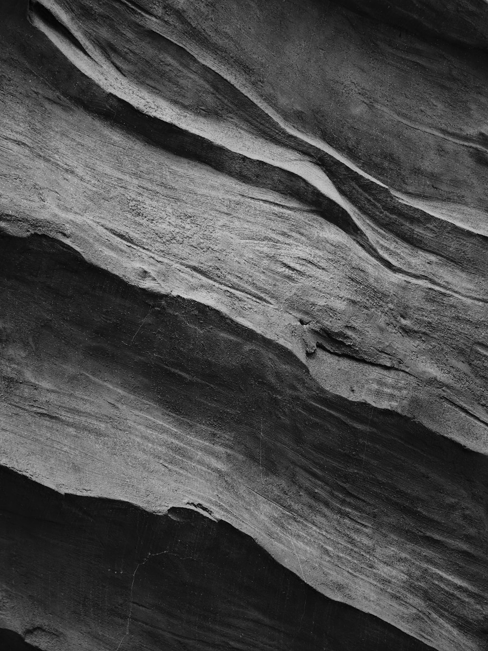 a black and white photo of a rock face