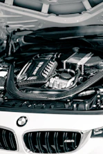 a white car with its hood open and a car engine