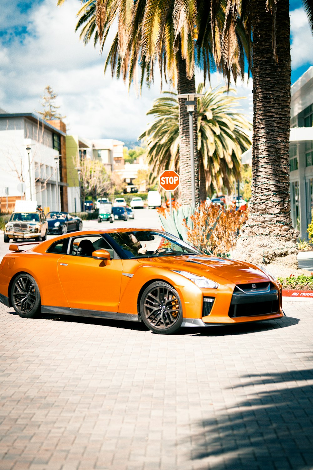 an orange sports car parked on the side of the road