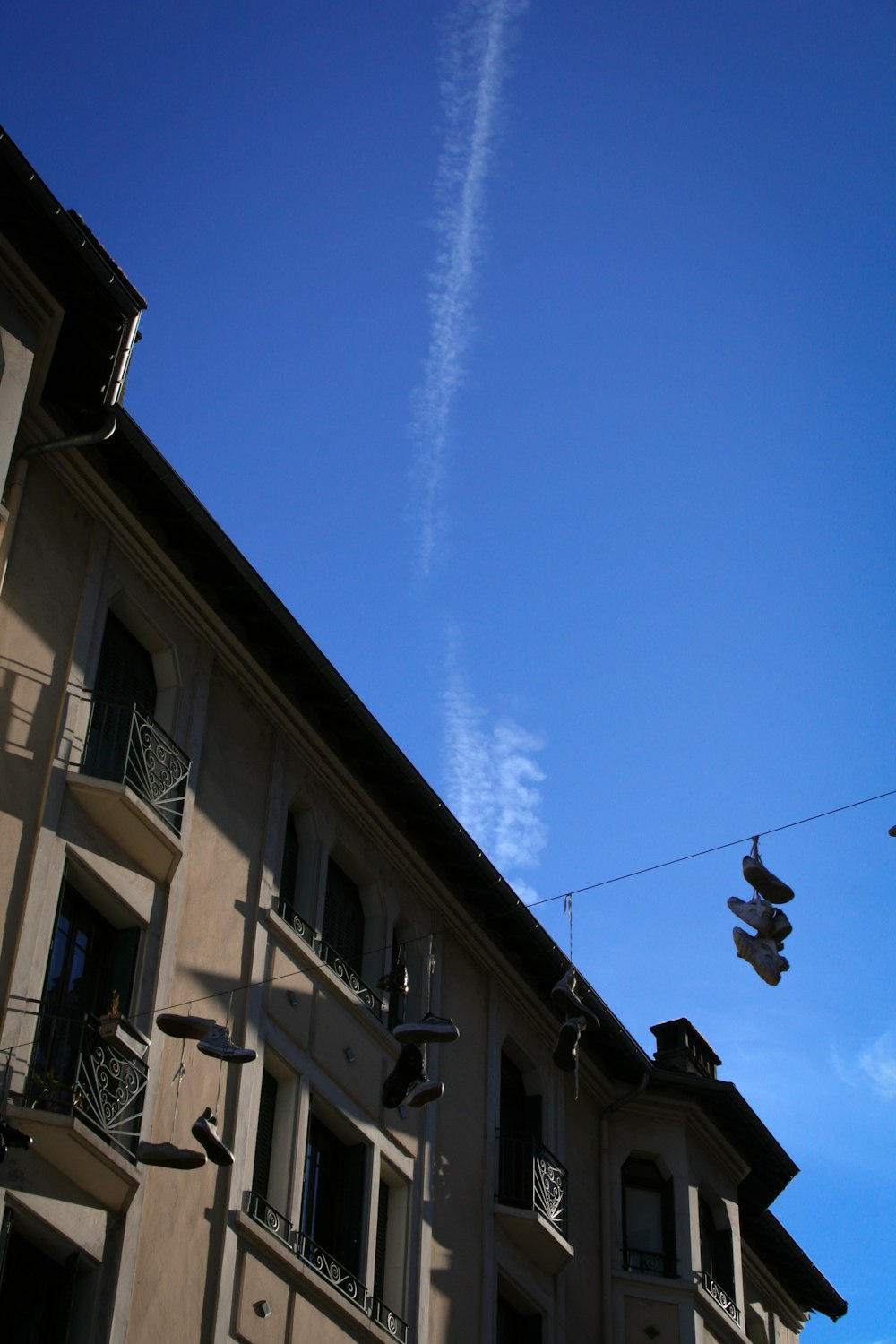 an airplane flying over a building with a sky background