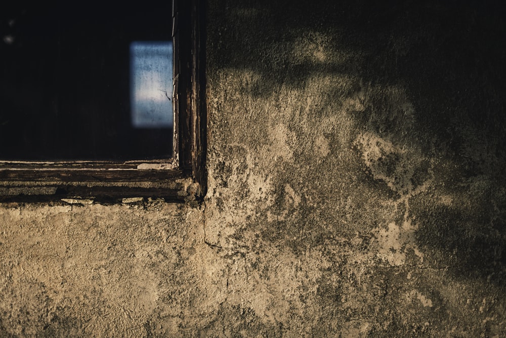 una ventana en una pared con un fondo oscuro