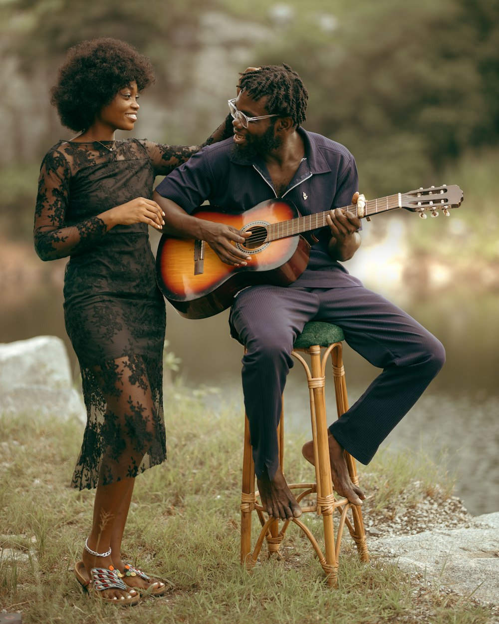 a man playing a guitar next to a woman