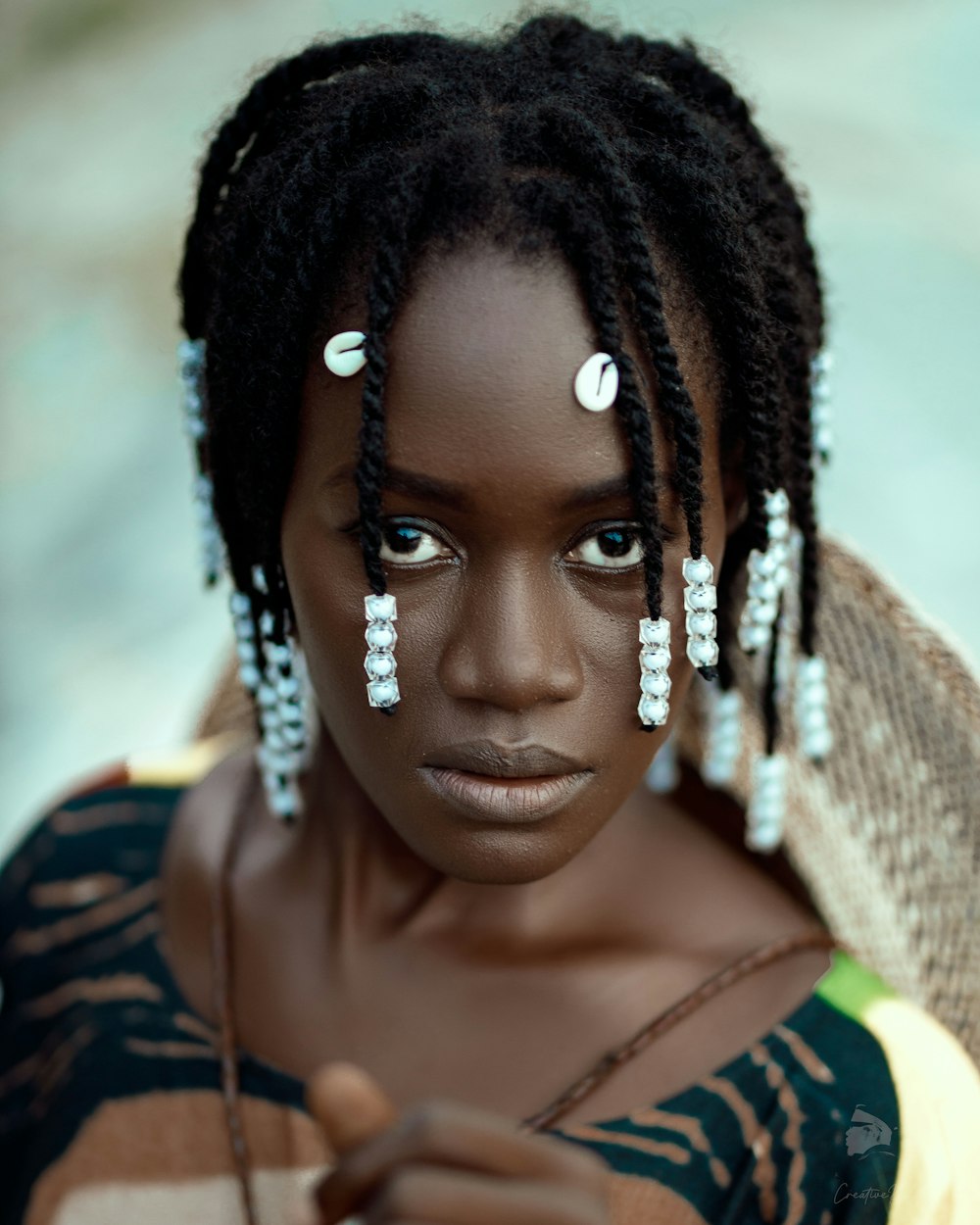 a woman with dreadlocks is looking at the camera