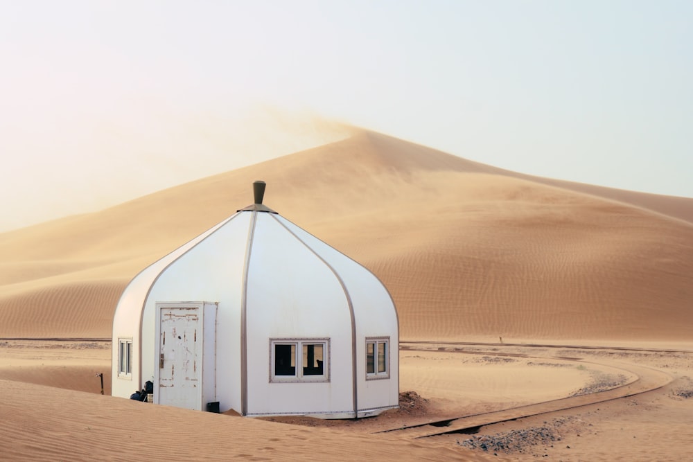 a white building sitting in the middle of a desert