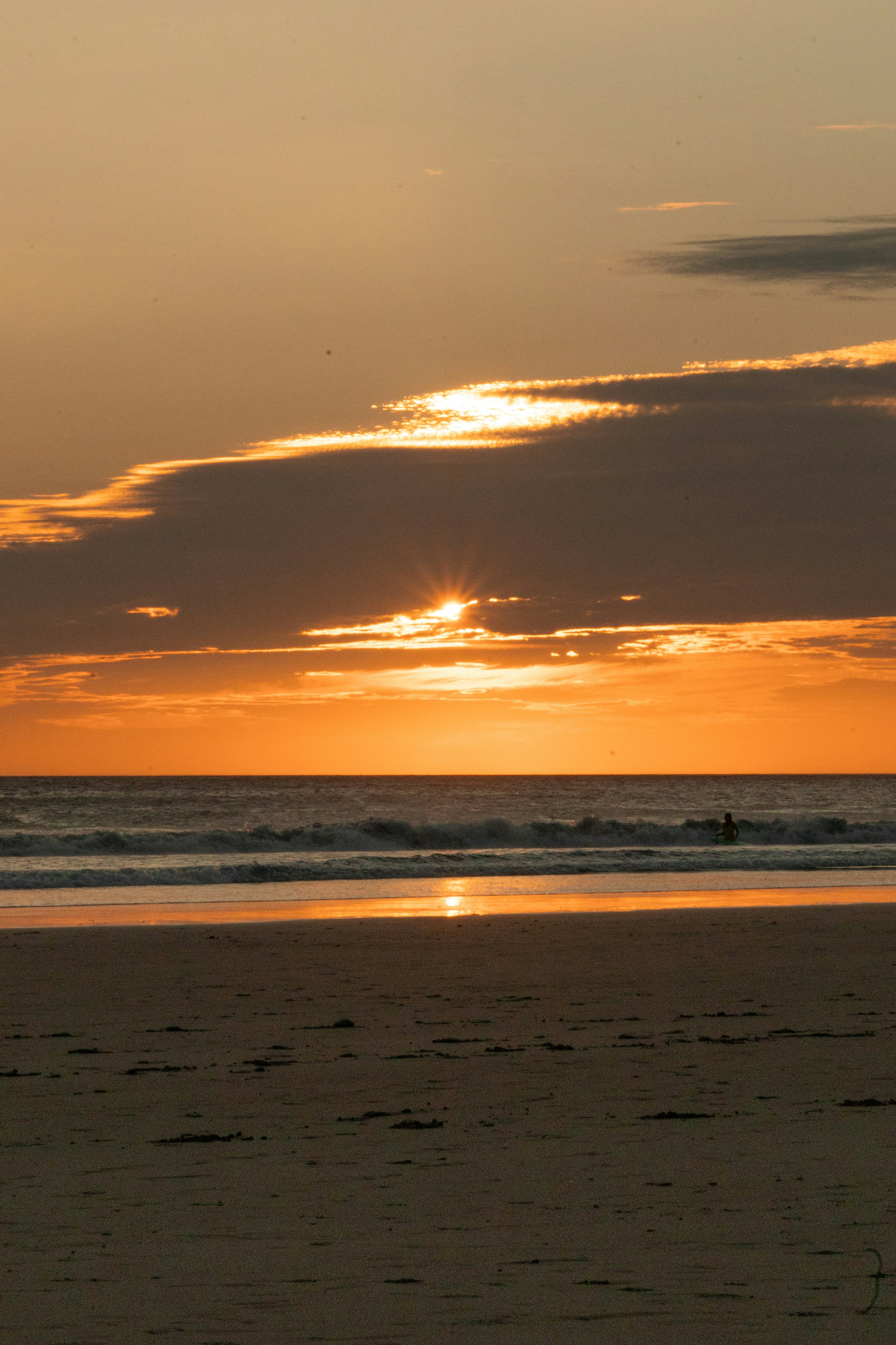 a person riding a surfboard on top of a sandy beach