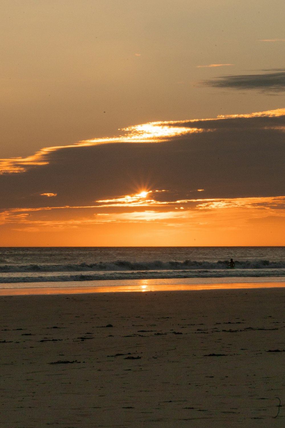 a person riding a surfboard on top of a sandy beach