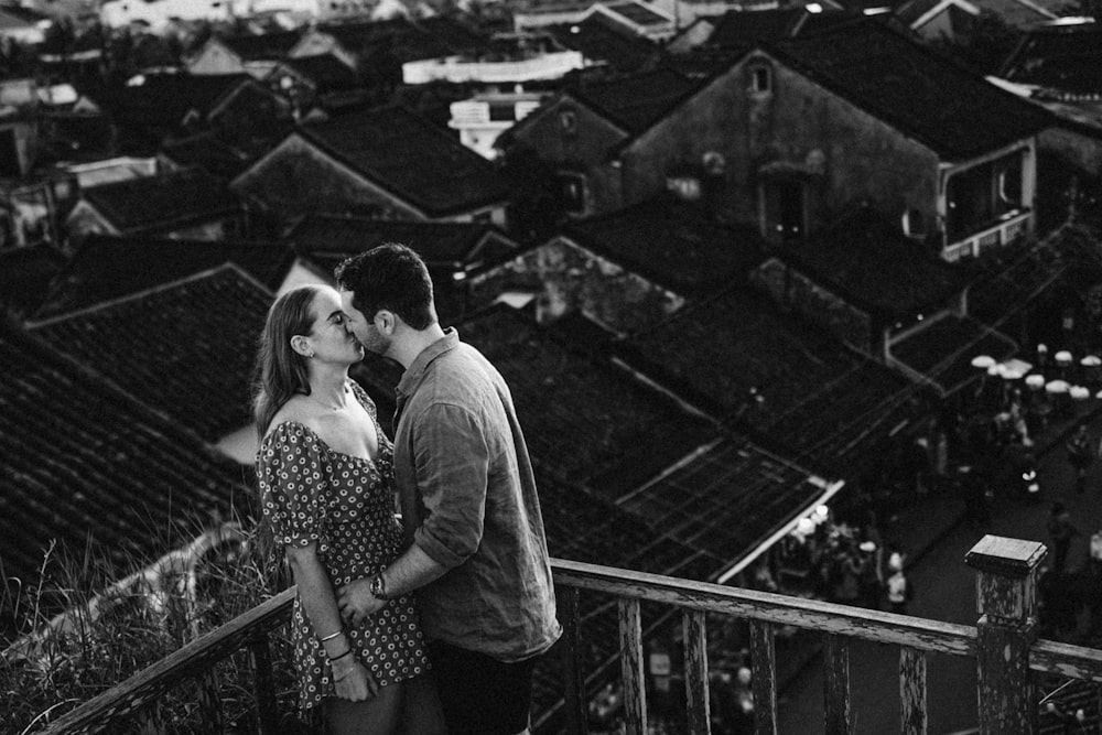 a black and white photo of a couple kissing